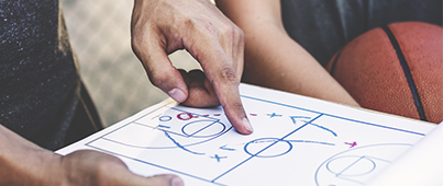 A basketball coach drawing up a game plan