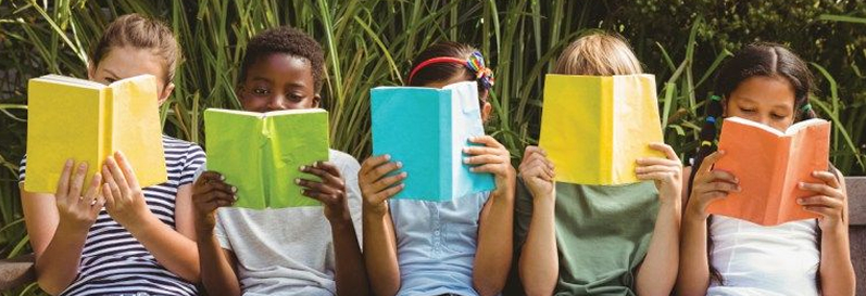 Five children sitting in a row outside reading colourful books