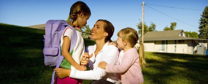 A mom outdoors with her two daughters