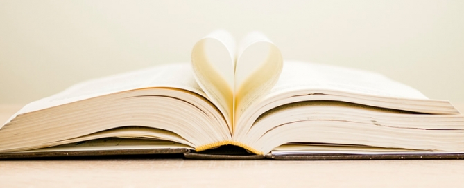 An open book with two pages folded into a heart shape