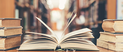 An open book on a desk inside of a library