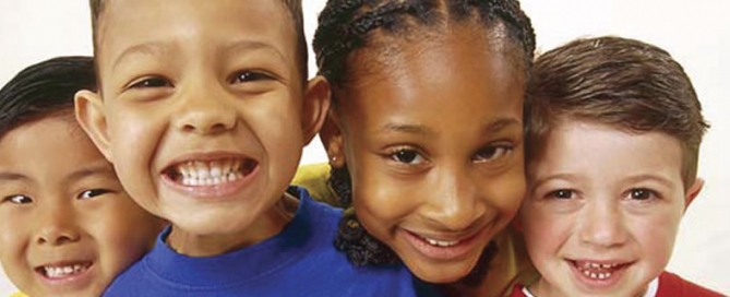 A group of four children smiling together