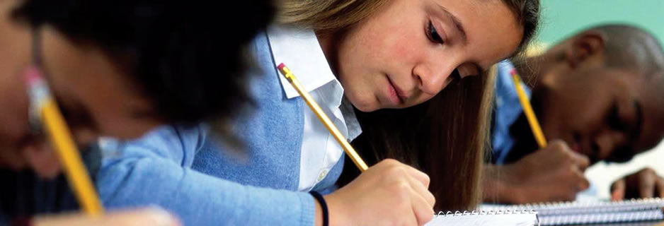 Three students writing in their notebooks