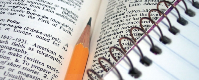 A pencil laying on an open dictionary